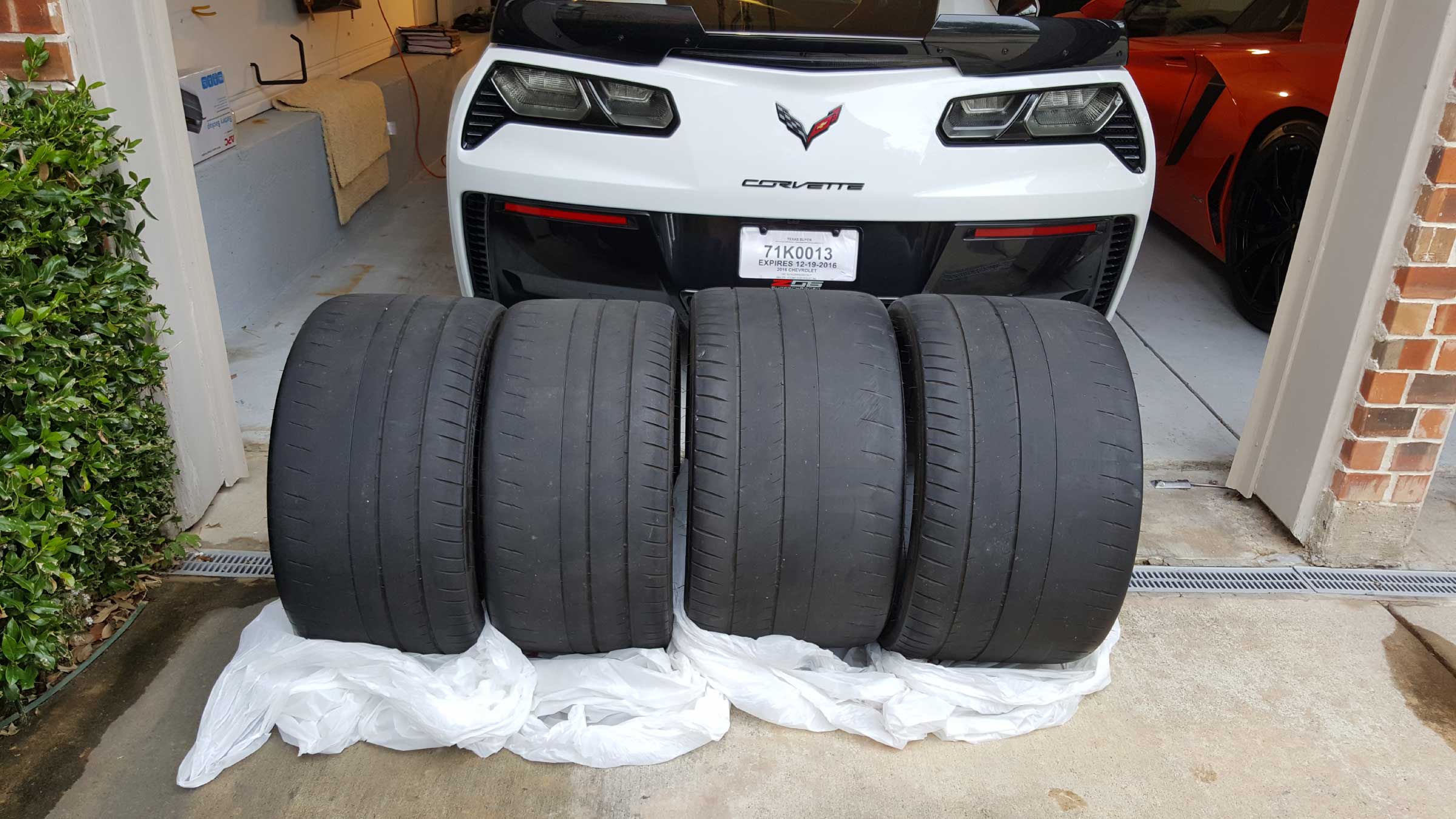 A set of Michelin Pilot Sport Cup 2 tires behind a Corvette